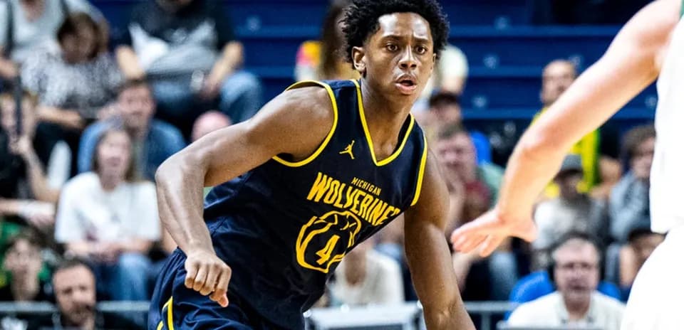 Jugador de baloncesto de Michigan driblando durante partido