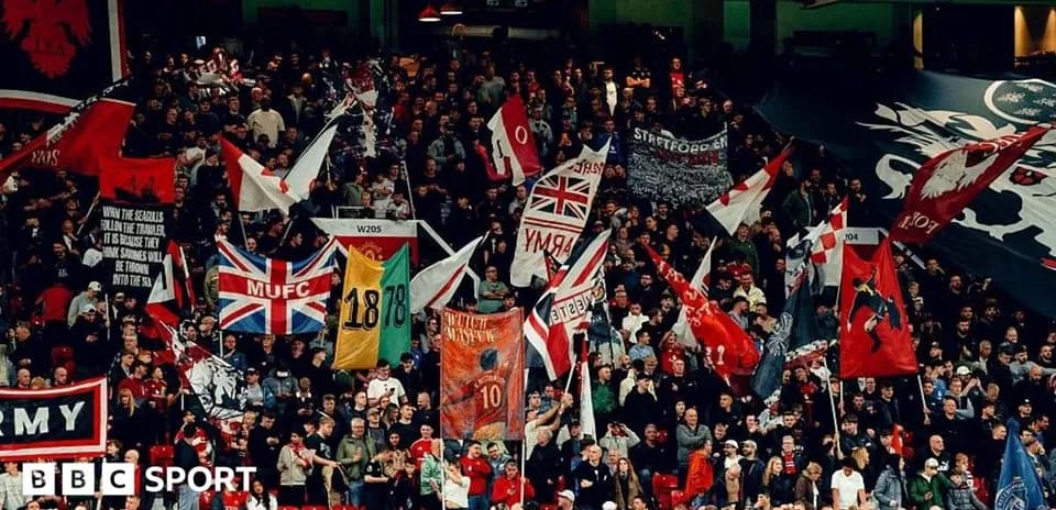 Aficionados con banderas en un estadio de fútbol