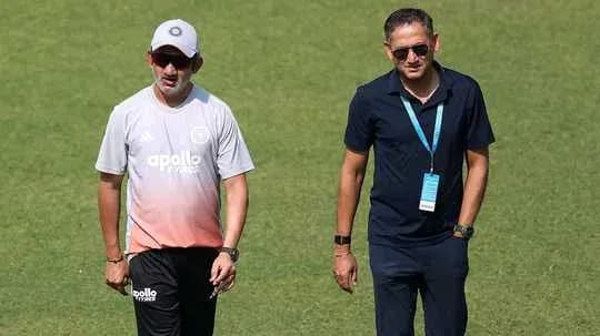 Entrenador y asistente caminando por el campo