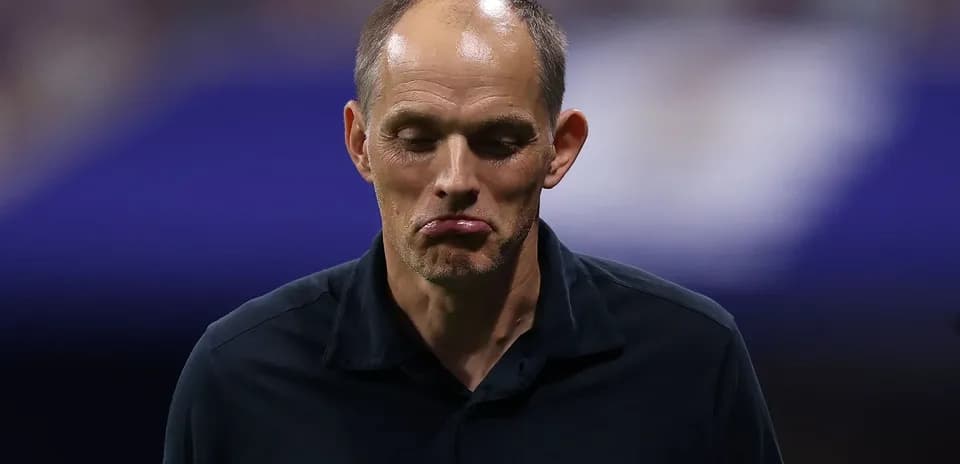 Entrenador caminando con expresión seria durante partido