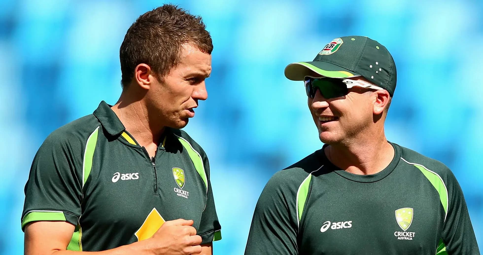 Dos jugadores de cricket conversando en el campo