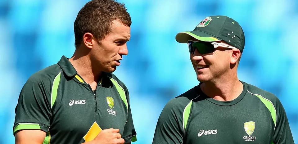 Dos jugadores de cricket conversando en el campo