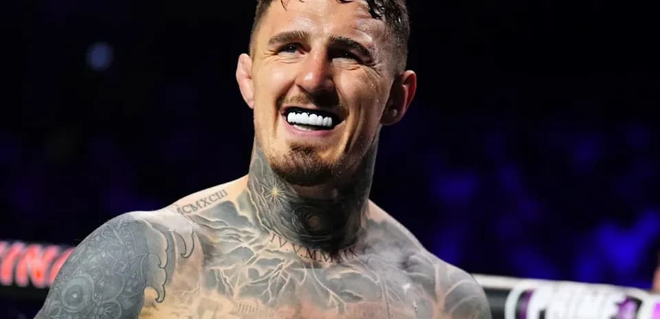 Boxeador sonriendo con tatuajes visibles en el torso