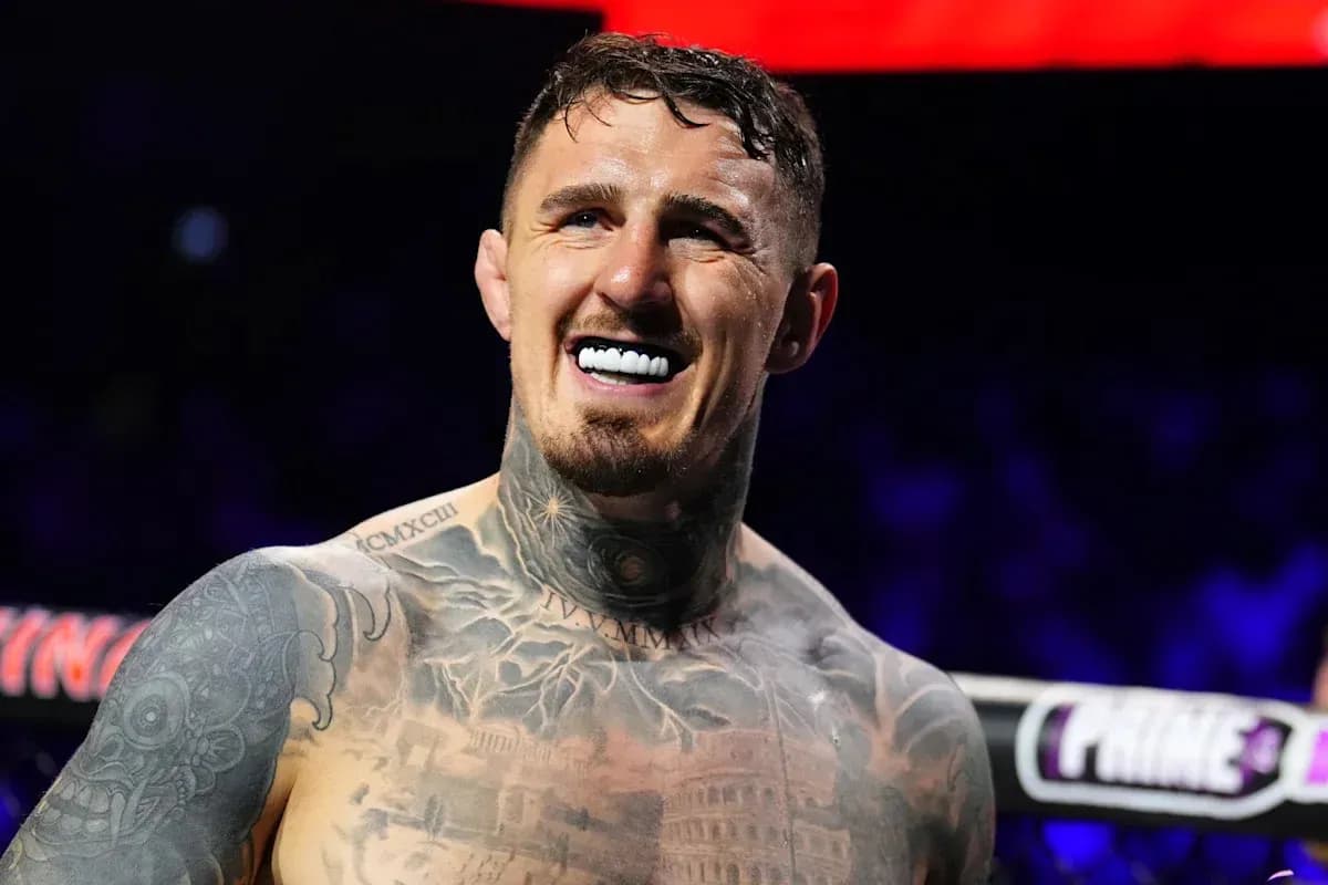 Boxeador sonriendo con tatuajes visibles en el torso