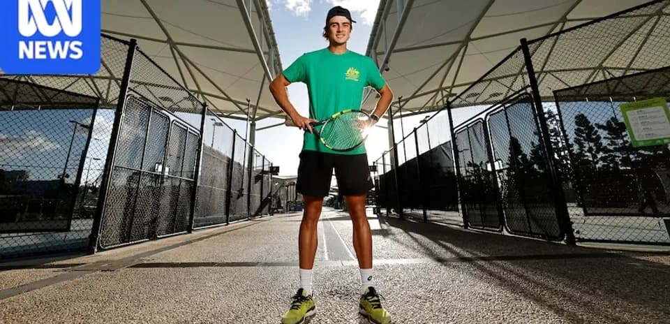 Jugador de tenis posando con raqueta en cancha