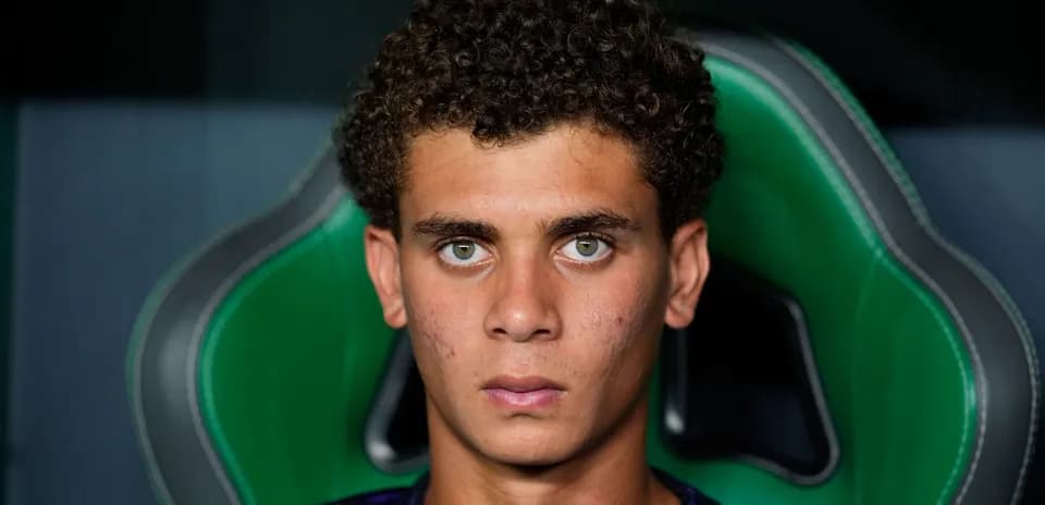 Joven jugador sentado en silla de equipo deportivo