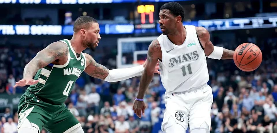 Jugador de los Mavericks driblando ante defensor de los Bucks