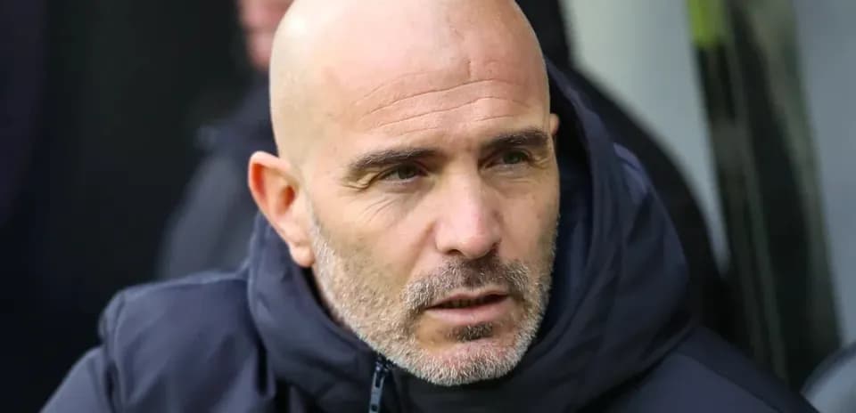 Entrenador observando el partido desde el banquillo