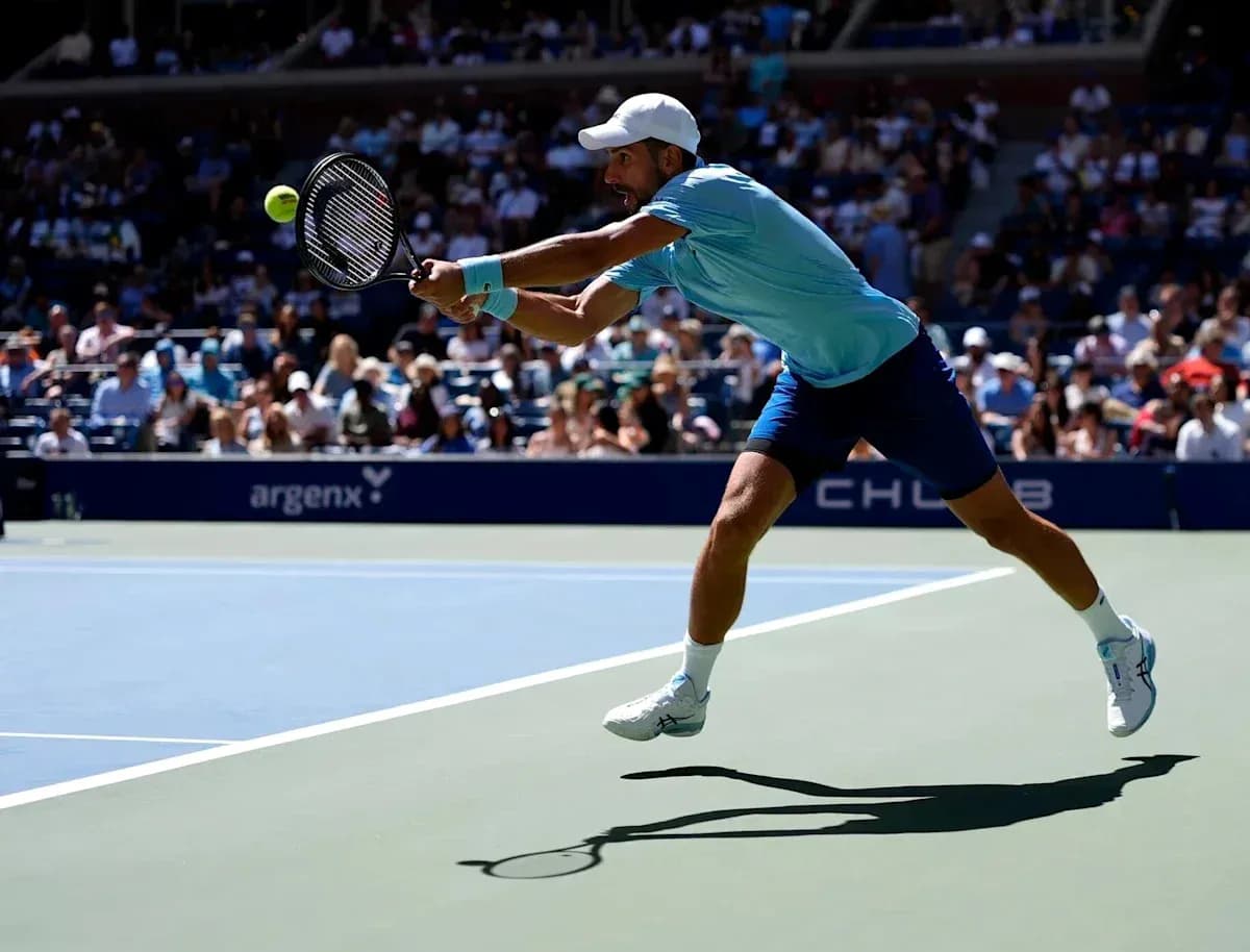 Jugador alcanzando la pelota durante un partido de tenis