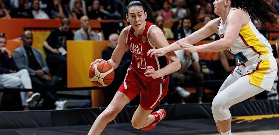 Jugadora de baloncesto driblando mientras es defendida