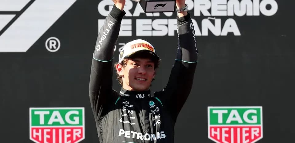 Piloto sosteniendo trofeo en el podio de Fórmula 1