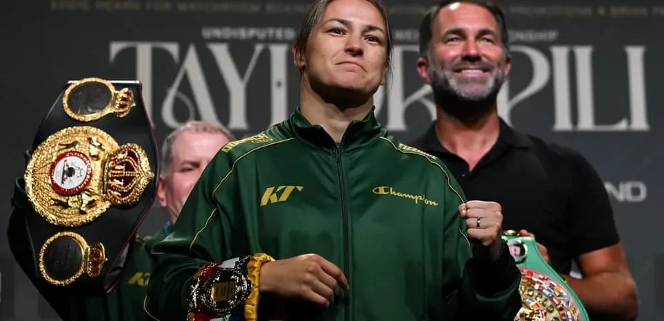 Boxeadora sosteniendo cinturones en evento de pesaje
