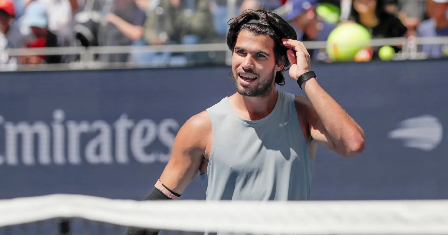 Jugador de tenis ajustándose el cabello durante el partido Jugador de tenis ajustándose el cabello durante el partido
