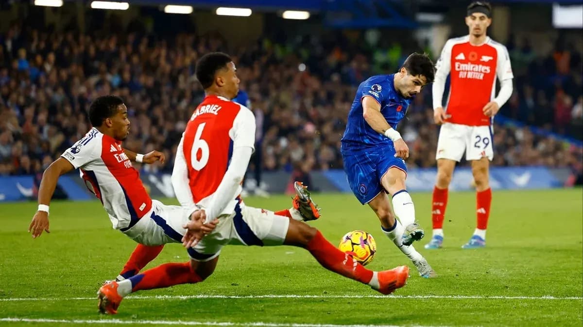 Jugador de Chelsea disparando mientras es defendido por Arsenal Jugador de Chelsea disparando mientras es defendido por Arsenal