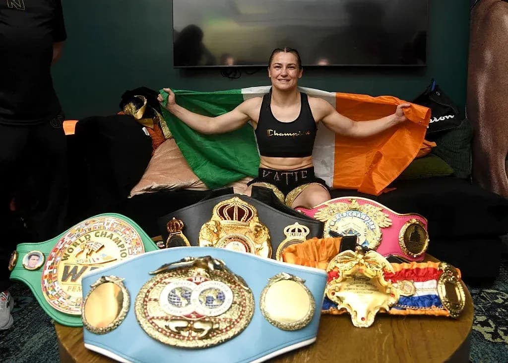 Boxeadora sosteniendo la bandera irlandesa con cinturones Boxeadora sosteniendo la bandera irlandesa con cinturones