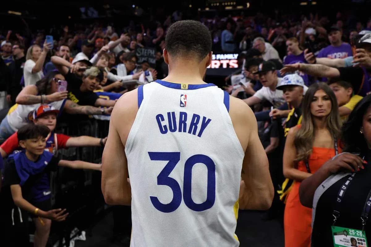 Jugador con camiseta de Curry saluda a la multitud Jugador con camiseta de Curry saluda a la multitud