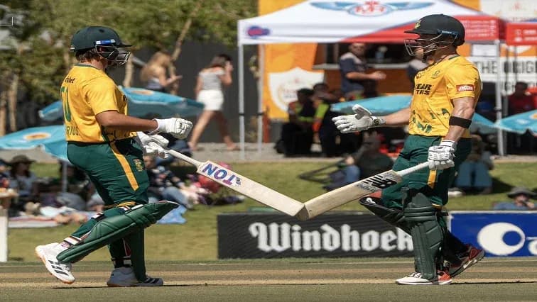 Jugadores chocando sus bates en el campo de cricket Jugadores chocando sus bates en el campo de cricket