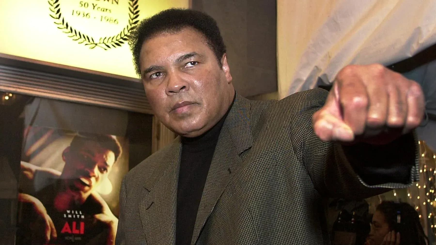 Muhammad Ali levantando el puño en un evento Muhammad Ali levantando el puño en un evento