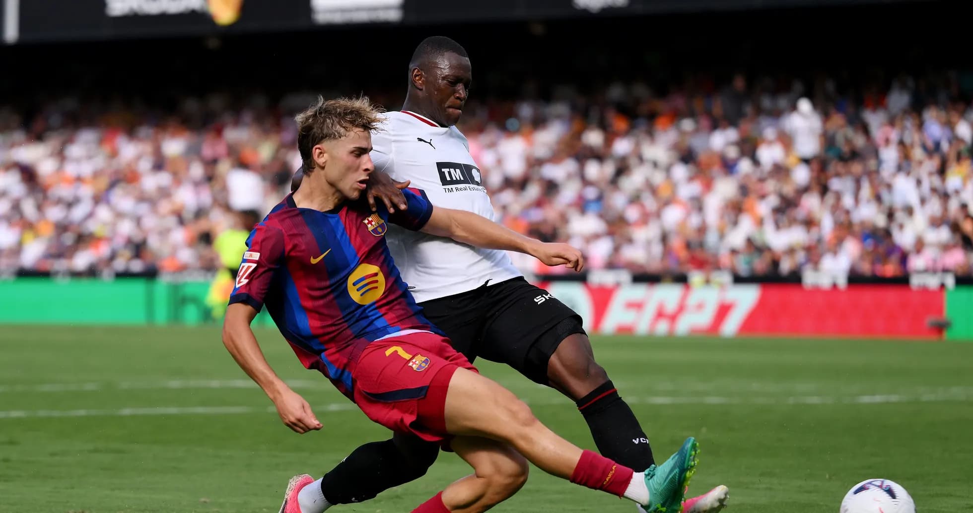 Jugador de Barcelona deslizándose para ganar el balón Jugador de Barcelona deslizándose para ganar el balón