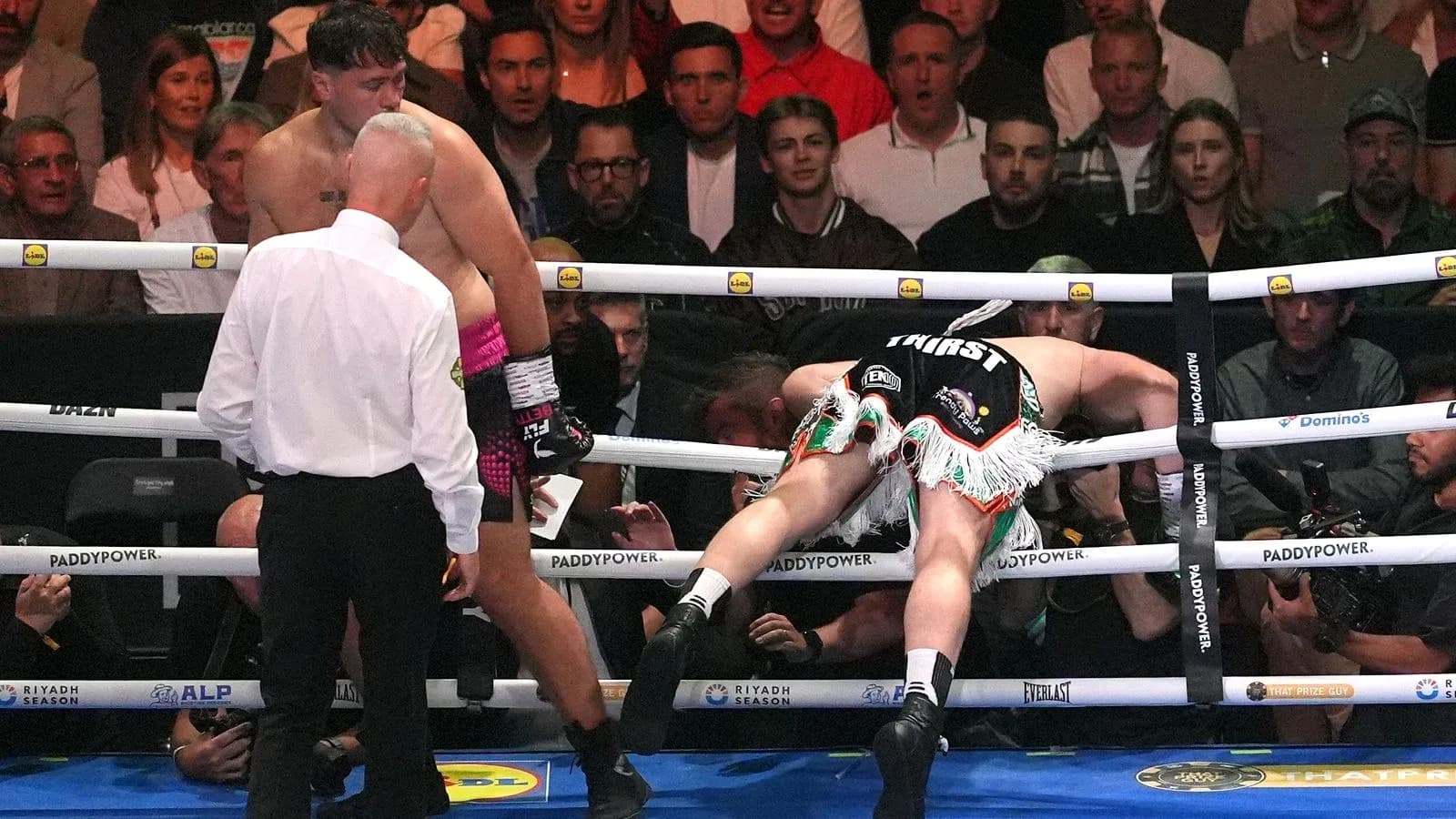 Boxeador caído en el ring durante la pelea Boxeador caído en el ring durante la pelea