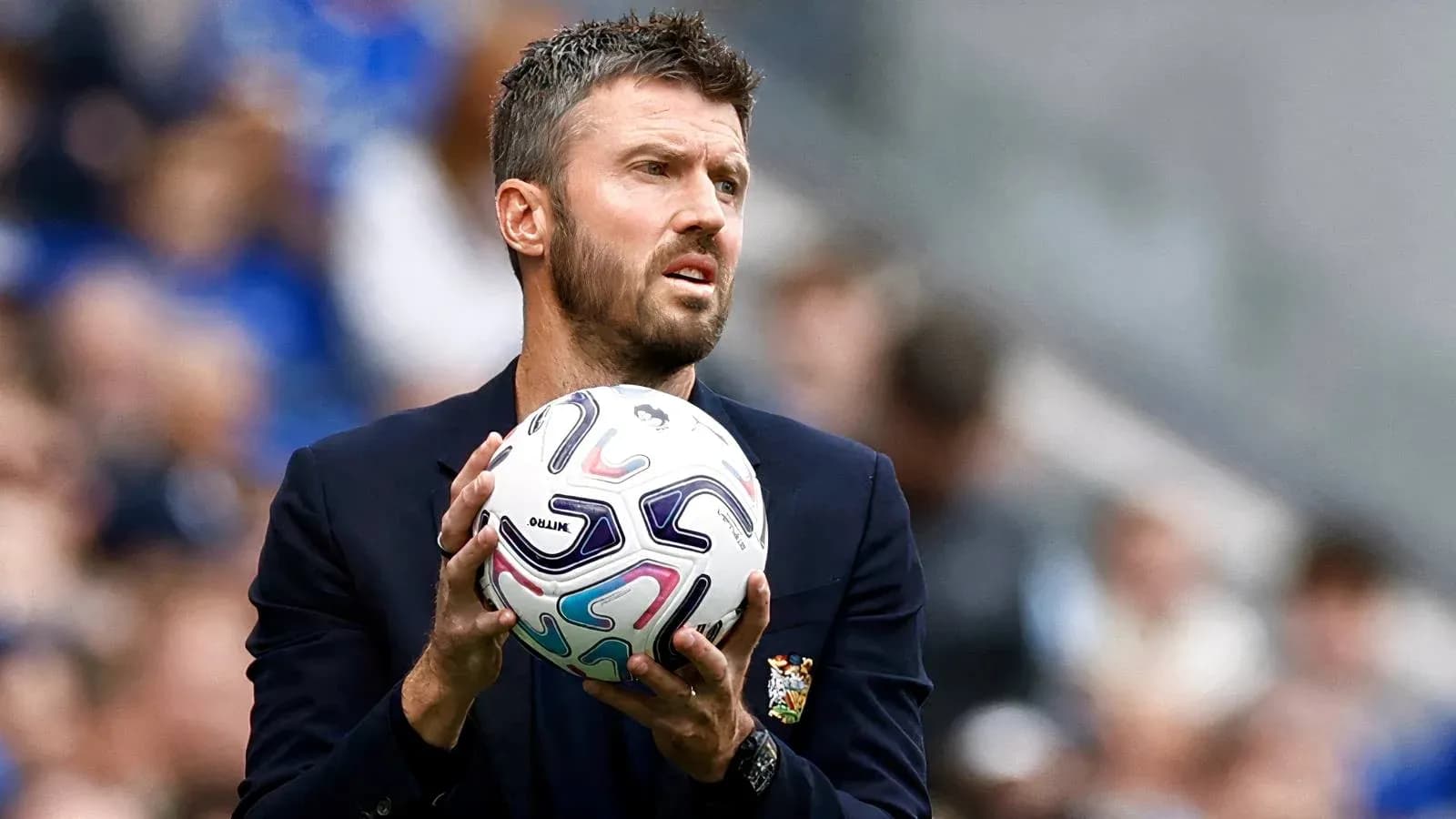 Entrenador sosteniendo un balón en el campo Entrenador sosteniendo un balón en el campo