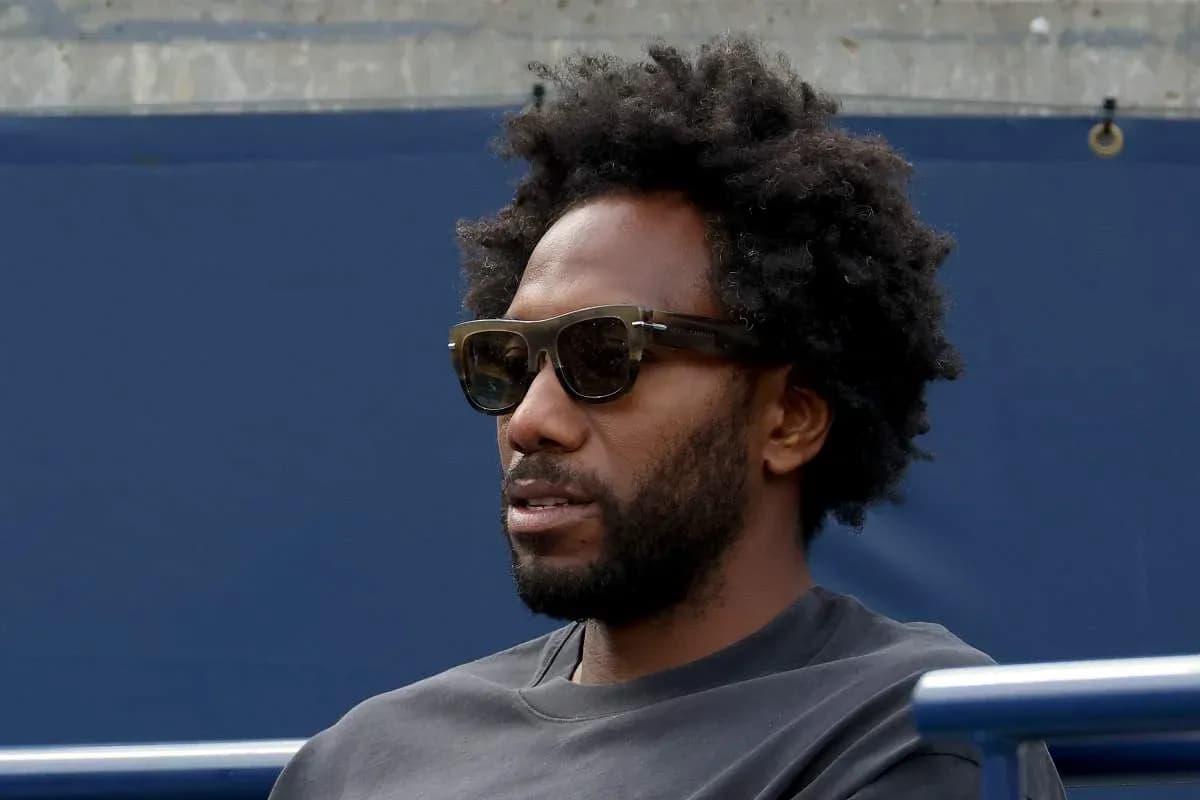 Hombre con gafas oscuras sentado en la grada Hombre con gafas oscuras sentado en la grada