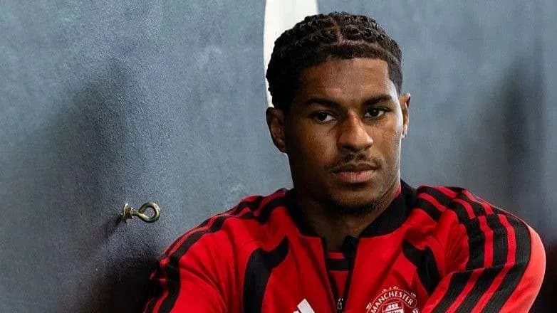 Jugador sentado en un vestuario con camiseta roja Jugador sentado en un vestuario con camiseta roja