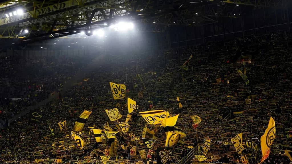 Aficionados de Borussia Dortmund con banderas en el estadio Aficionados de Borussia Dortmund con banderas en el estadio