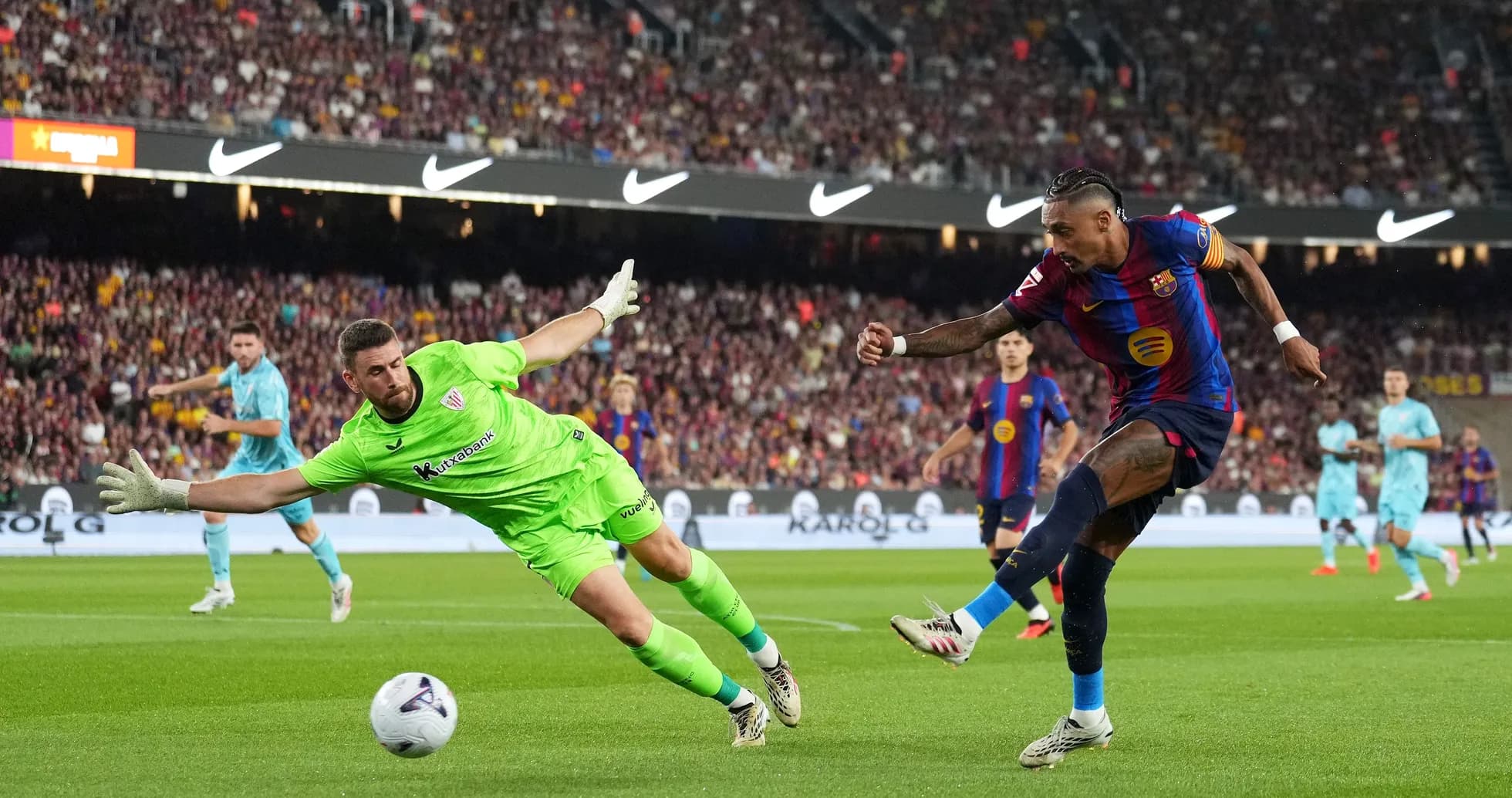 Jugador de Barcelona dispara mientras el portero intenta detenerlo Jugador de Barcelona dispara mientras el portero intenta detenerlo