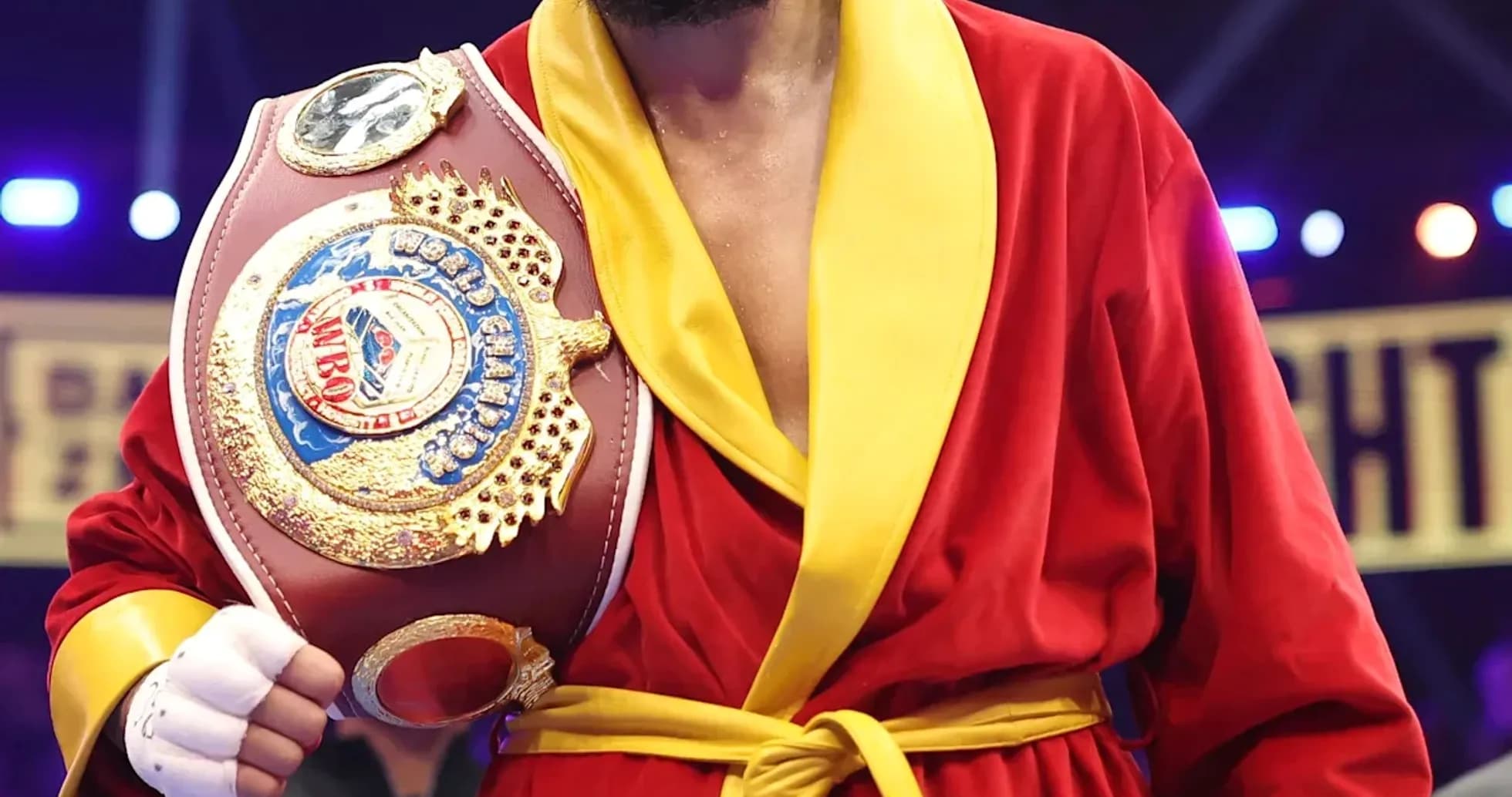 Boxeador con cinturón en bata roja y amarilla Boxeador con cinturón en bata roja y amarilla